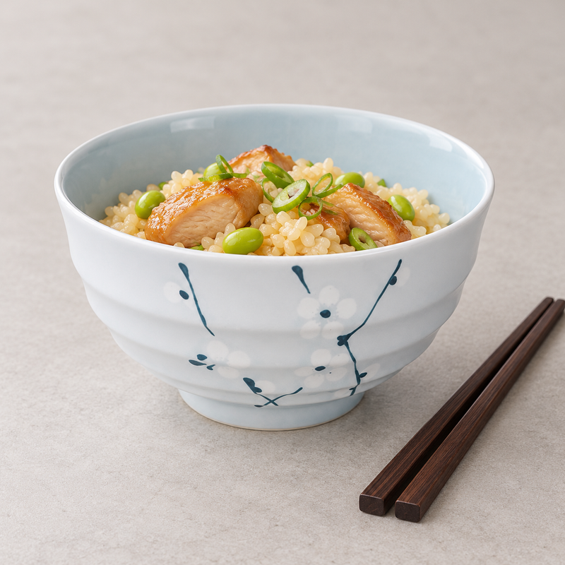 Floral ceramic bowl serving rice, chicken, edamame and scallions