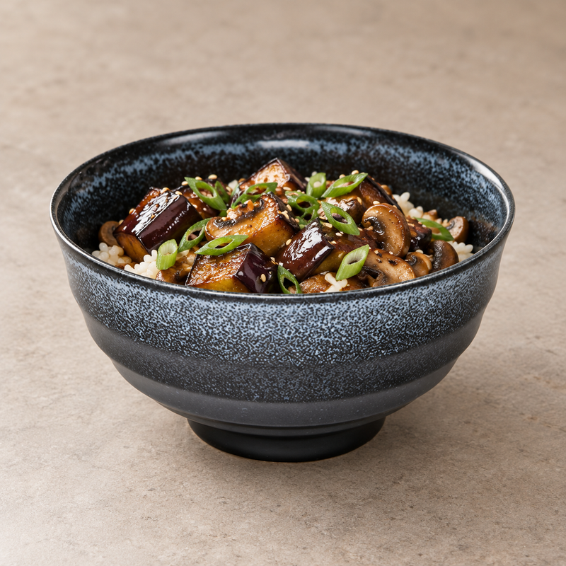 Black speckled bowl serving rice, eggplant, mushrooms, scallions and sesame