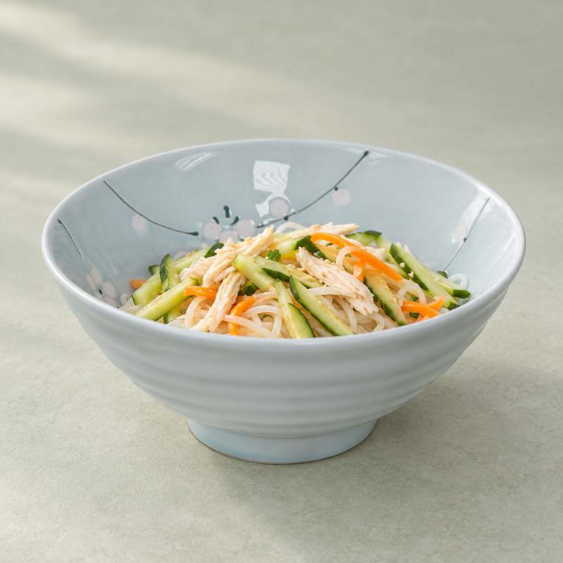 Floral bowl serving pale noodles, cucumber, carrot and shredded meat