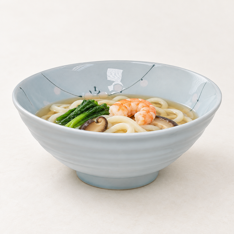 Floral bowl serving thick noodles, shrimp, mushrooms and greens in broth