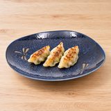 BD28-N navy Dragonfly ceramic plate with three vegetable gyoza on a light wooden table