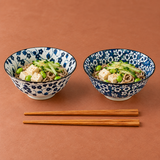 Two patterned bowls with noodles and one pair of chopsticks