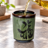 Tea poured into the green calligraphy teacup