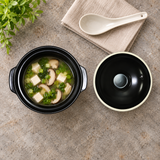 C5-BK black ceramic pot with tofu and vegetable soup and its lid alongside