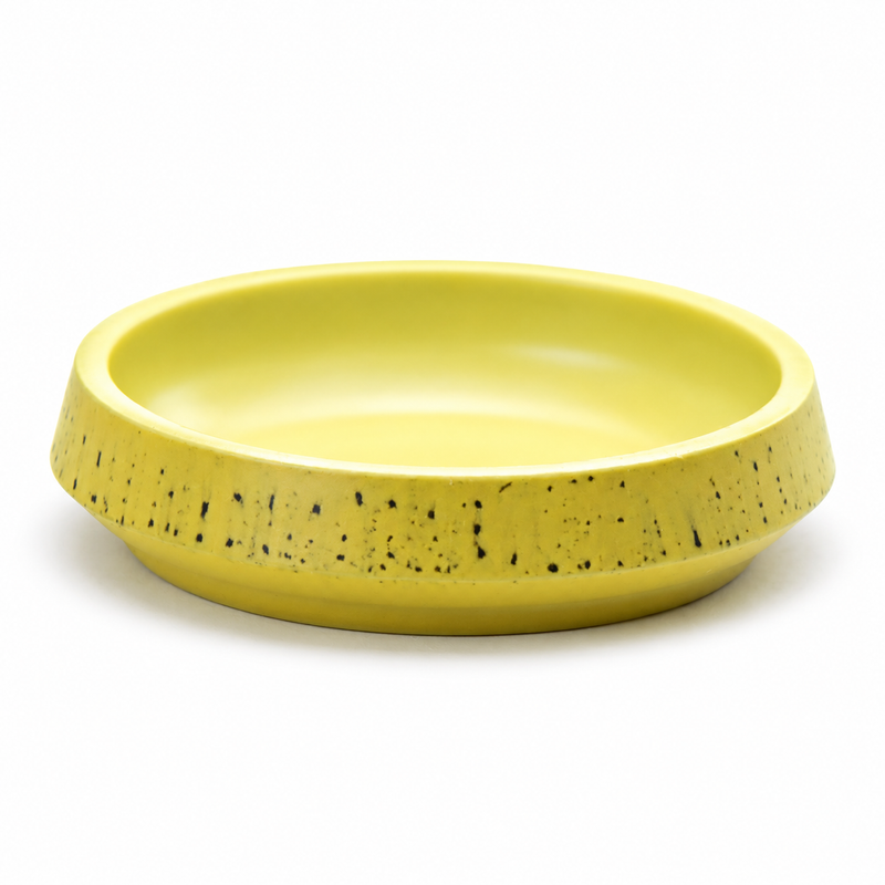 Angled view of the empty yellow 72-77-9 melamine dipping dish showing its low round well and broad flecked outer band.