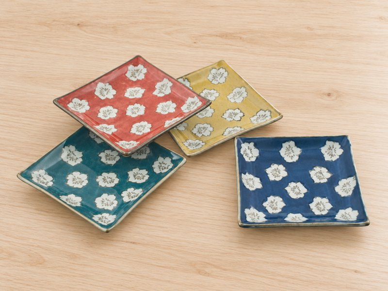 Four GY13-11S square plates with spaced white floral medallions on a light wooden table