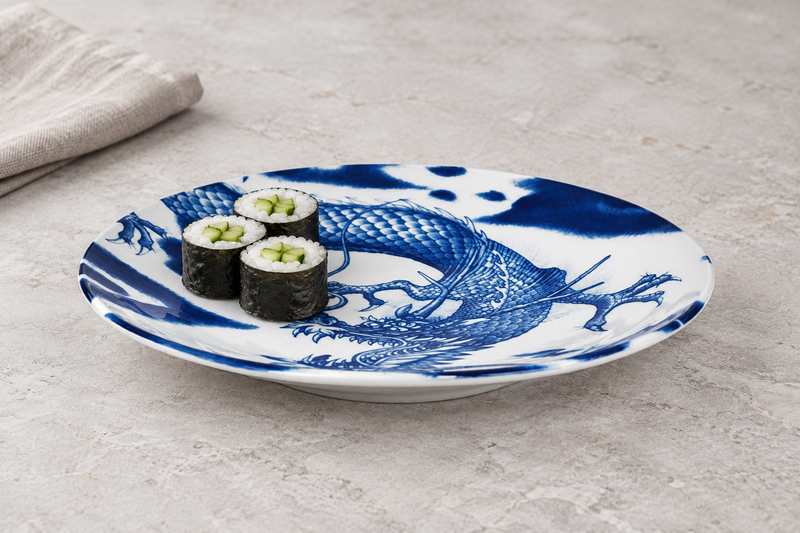 Blue dragon ceramic plate with three cucumber maki on a pale stone table