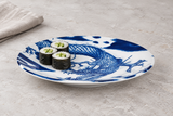 Blue dragon ceramic plate with three cucumber maki on a pale stone table