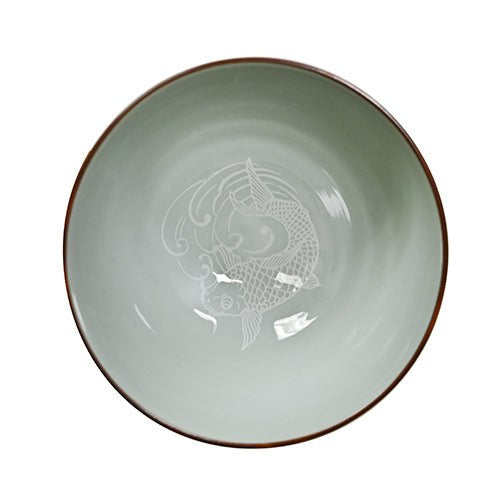 Blue koi bowl viewed from above with a pale green interior, central white koi outline and brown-red rim.