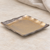 Gold and brown square plate in a natural tabletop setting