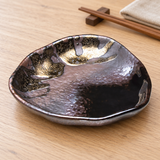 Dark and gold triangular side dish on a dining table