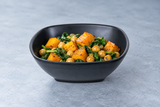 Black square bowl with squash and chickpeas
