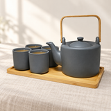 JHS6-BK tea set with tea in four cups on its tray, shown on a linen table.