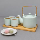 JHS6-GR tea set with four filled cups and a separate plate of two mochi sweets and a fork.