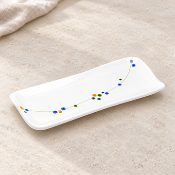 White rectangular floral-vine plate in a natural tabletop setting