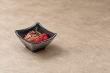 Black square sauce dish with chocolate mousse and raspberries