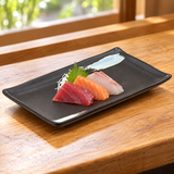 JX289-E black ceramic sushi plate with pale-blue corner accents serving sashimi