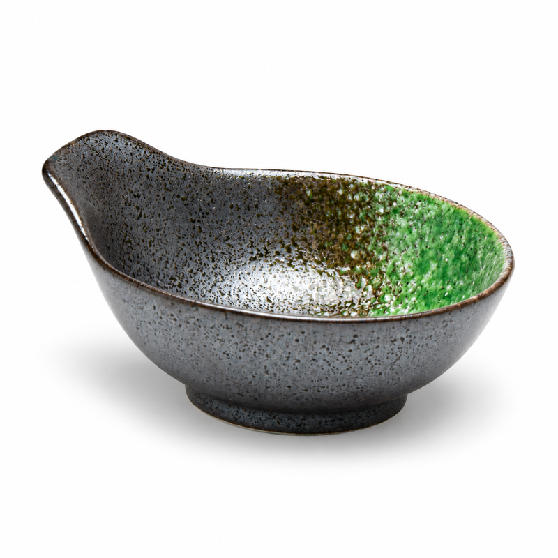 Gray-black porcelain sauce bowl with raised tab handle, short foot and green-and-pale mottling inside.