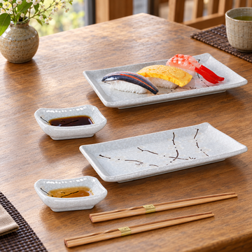 JX79-WP sushi plate and dish set with two chopstick pairs with sushi on a restaurant table