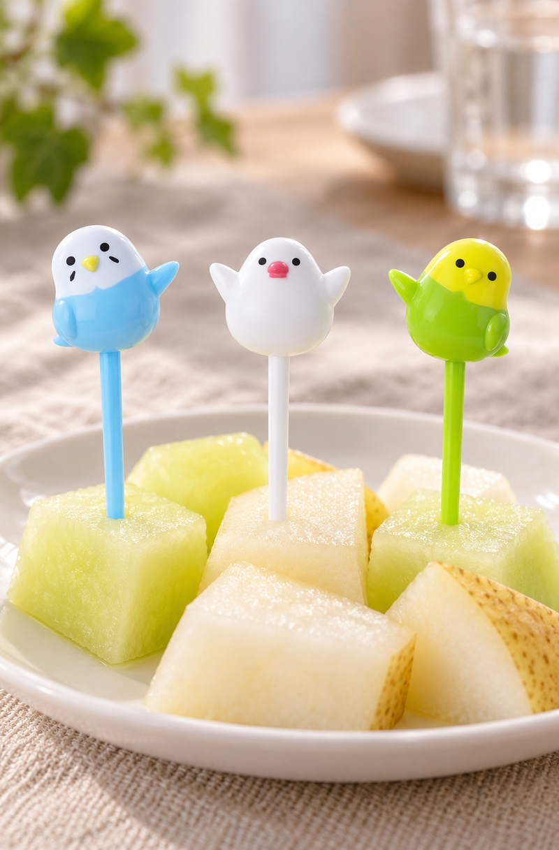 Three raised-wing bird picks with stems inserted into small fruit portions
