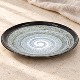 Patterned round plate on a stone tabletop