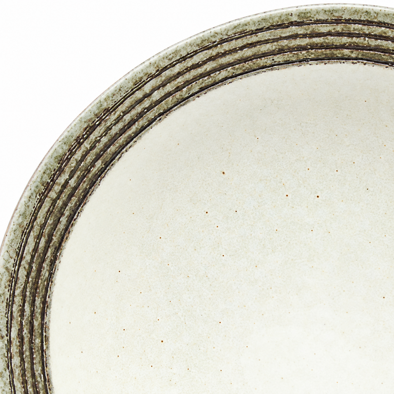 Close view of dark concentric rim bands and the pale speckled center of the K511/KB noodle bowl