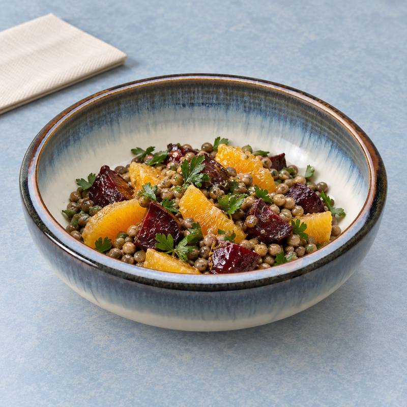 Orange segments, beet pieces, lentils and green herbs in the K59-A blue-grey bowl beside a folded napkin