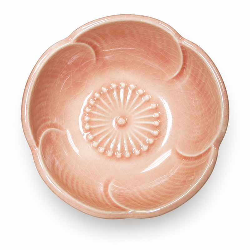 Pink shallow flower-shaped ceramic bowl with pale curved petal detail and a small radial center.