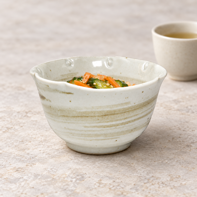Cream whirlpool-pattern bowl holding a small vegetable serving, with olive-brown bands visible on the outside.