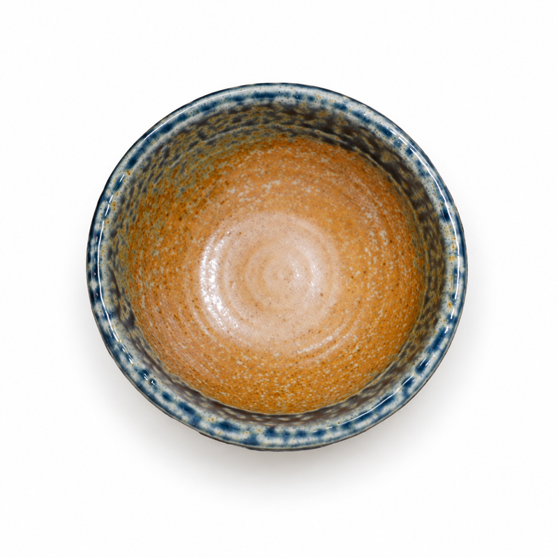 Overhead view of the mini bowl with amber-brown interior and mottled blue-green and cream rim.