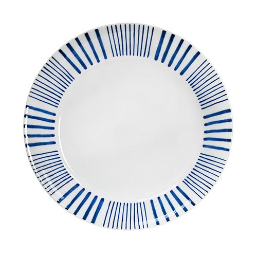 Overhead view of the white shallow bowl showing alternating thick and fine groups of blue radial stripes around the inner rim.