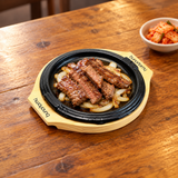 HYS03 round iron steak plate with wooden base — sliced beef serving suggestion