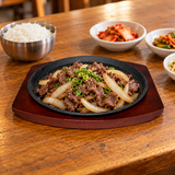 NTP-05 round iron steak plate with wood base — sliced beef serving suggestion