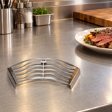 Stainless-steel Korean BBQ meat resting rack beside a serving plate