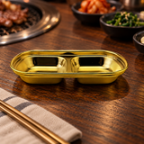 ssg-sap2-6 gold divided sauce dish on a restaurant table