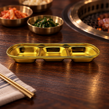 ssg-sap3-8 gold divided sauce dish on a restaurant table