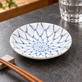 KN235-N blue tied-net sauce dish beside chopsticks on a rest and a water glass
