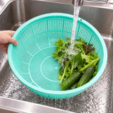 Green L1 colander rinsing greens and cucumbers under cool water