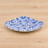 Blue and white arabesque square ceramic plate on a pale wooden table