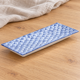 Blue and white rectangular ceramic plate in a natural tabletop setting