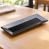 Black rectangular melamine dish in a natural tabletop setting