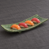 Narrow green ridged ceramic plate with four nigiri sushi pieces