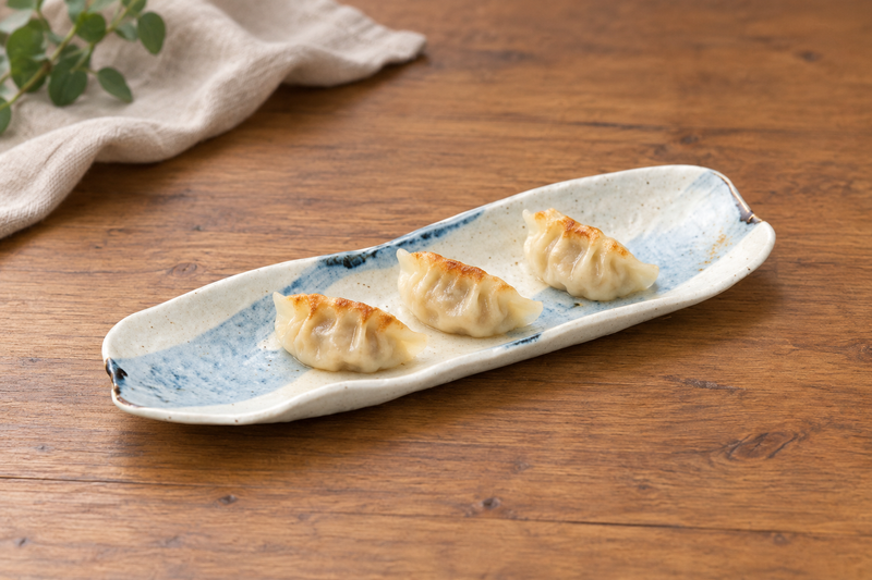 Beige and pale blue curved platter with three dumplings