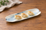 Beige and pale blue curved platter with three dumplings