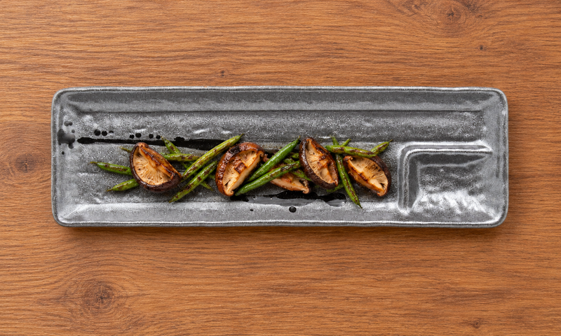 Dark brush-pattern ceramic platter with mushrooms and green beans