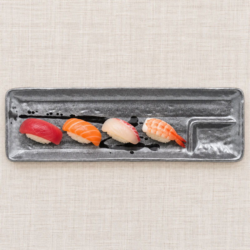 Dark brush-pattern rectangular ceramic platter with four nigiri