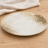 Beige and brown round ceramic plate in a natural tabletop setting