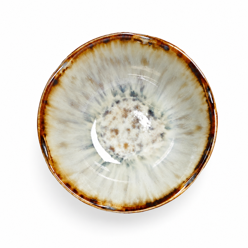 Overhead view of the small cream ceramic bowl with flowing gray marks and a dark brown rim.
