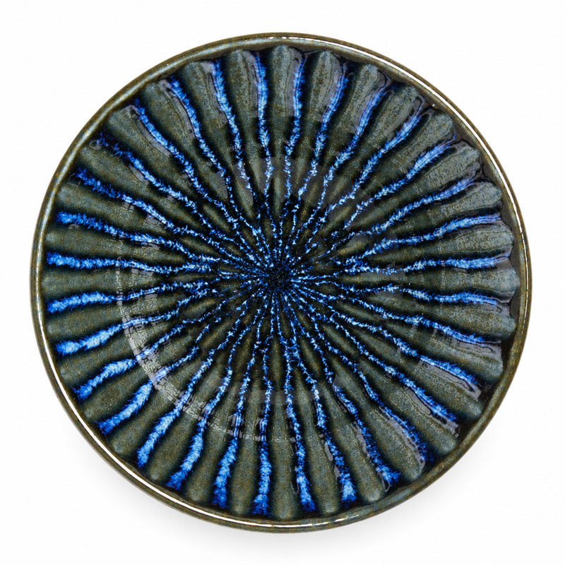 Overhead view of a dark shallow bowl with bright blue radial interior lines and muted olive-gray details.