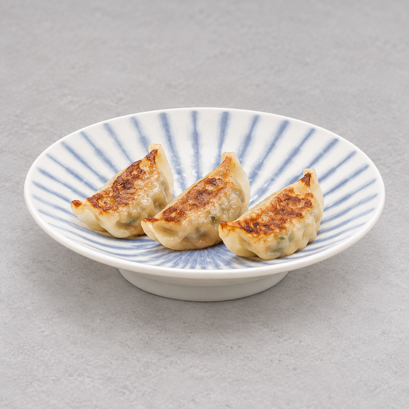 Shallow white and blue-striped ceramic bowl holding three golden-brown dumplings on a pale tabletop.